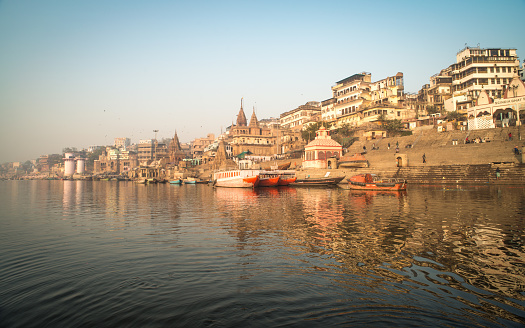 Varanasi India ancient city architecture view at sunset as seen from a boat on river Ganges.