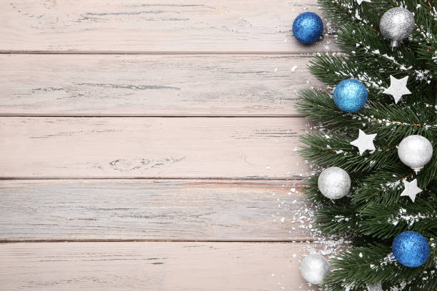 istock Christmas fir tree branches with decorations on wooden table 1077653468