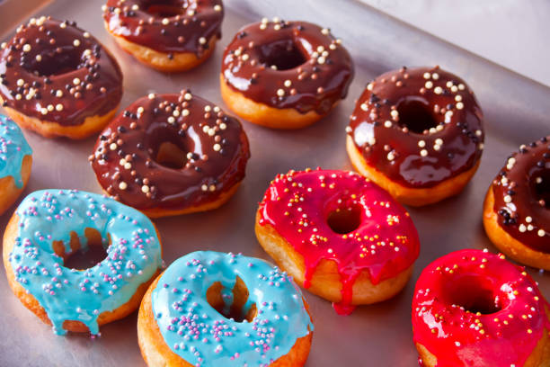 istock Fresh colorful chocolate donuts on the baking tray 1077653506