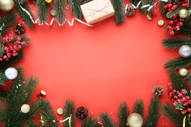 istock Christmas decorations with fir tree branches on red background 1077653858