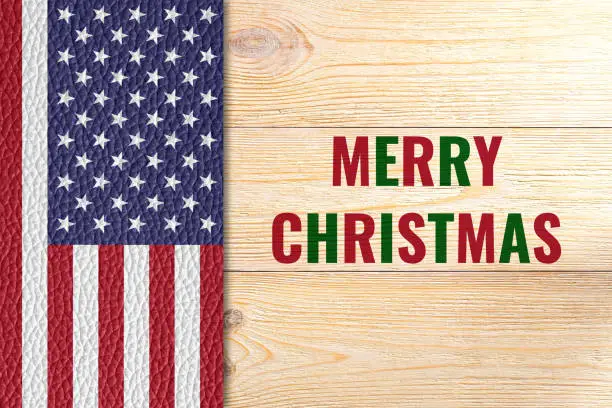 Merry Christmas, greeting card with us flag on wooden table