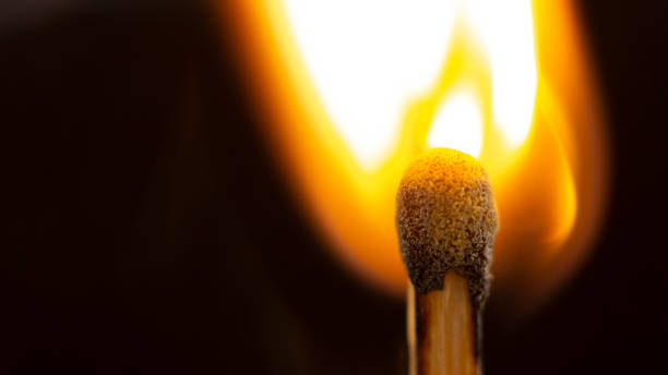 istock Burning wooden match with a red match head on a black background. 1077661286