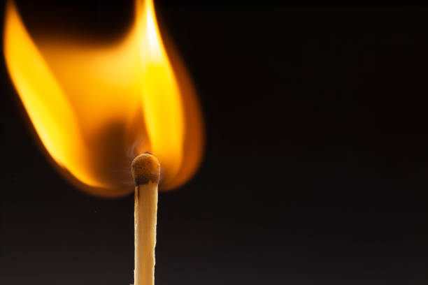 istock Burning wooden match with a red match head on a black background. 1077661310