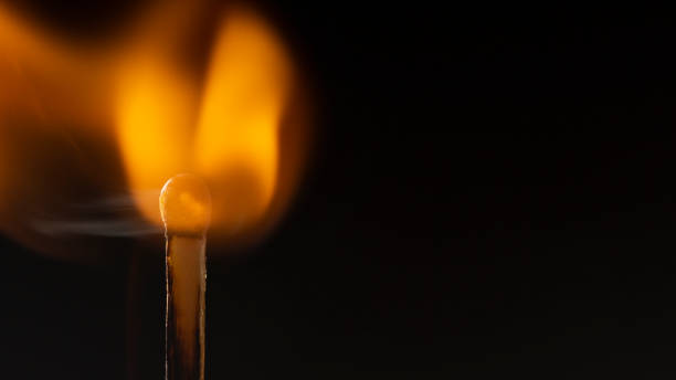 istock Burning wooden match with a red match head on a black background. 1077661412