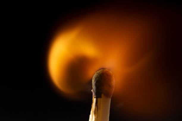 istock Burning wooden match with a red match head on a black background. 1077661452