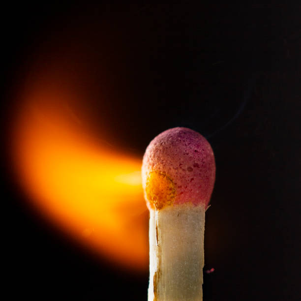 istock Burning wooden match with a red match head on a black background. 1077661454