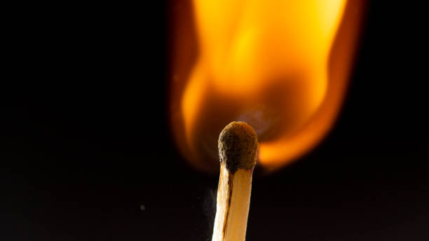 istock Burning wooden match with a red match head on a black background. 1077661458