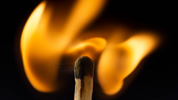 istock Burning wooden match with a red match head on a black background. 1077661462
