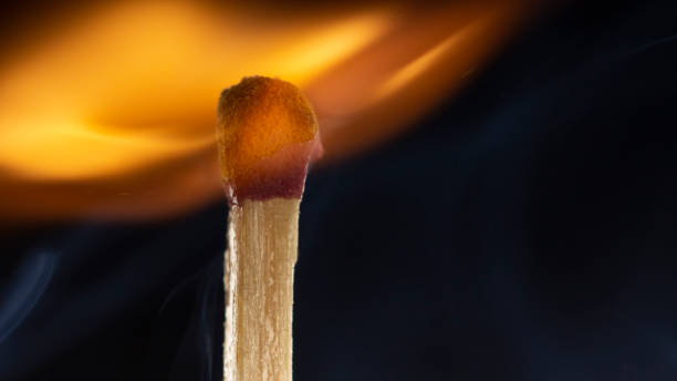 istock Burning wooden match with a red match head on a black background. 1077661498
