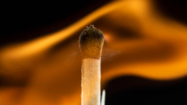 istock Burning wooden match with a red match head on a black background. 1077661506