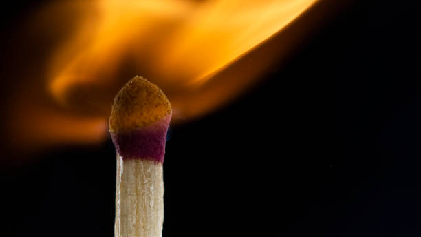 istock Burning wooden match with a red match head on a black background. 1077661522