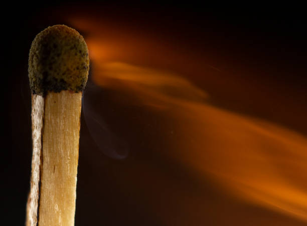 istock Burning wooden match with a red match head on a black background. 1077661526