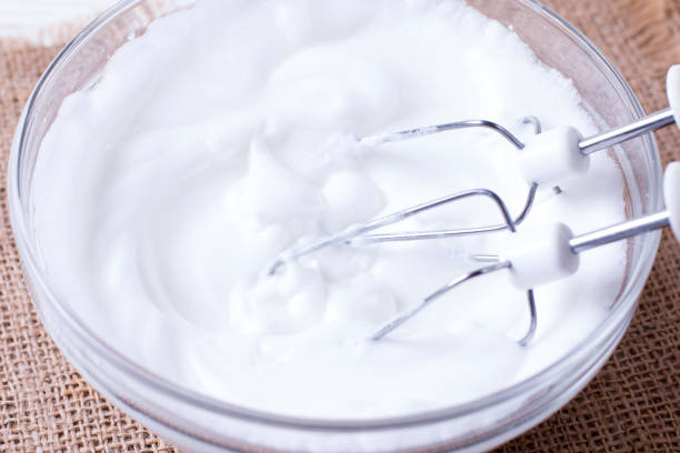 istock Whipped egg whites and other ingredients for cream on wooden table 1077665420