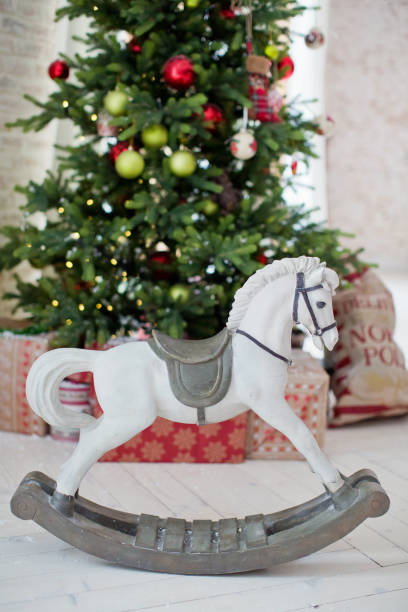 istock vintage rocking horse near Christmas tree 1077668364