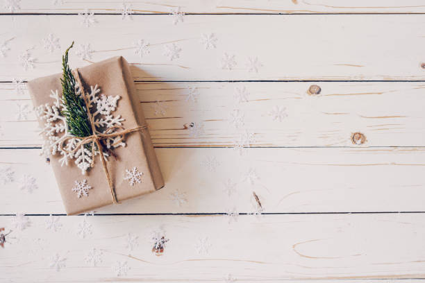 istock Brown gift box and Christmas presents on white wooden table background. 1077674390