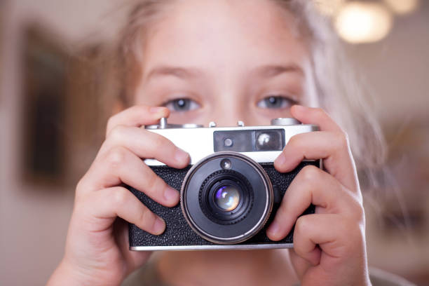 istock Girl with a retro camera makes a photo, close up. 1077674772