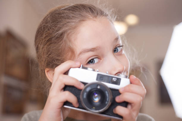istock Girl with a retro camera makes a photo. 1077674780