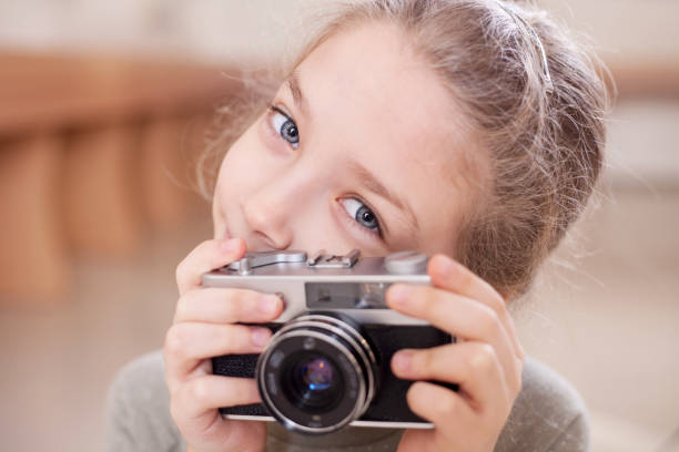 istock Girl with a retro camera makes a photo. 1077674782