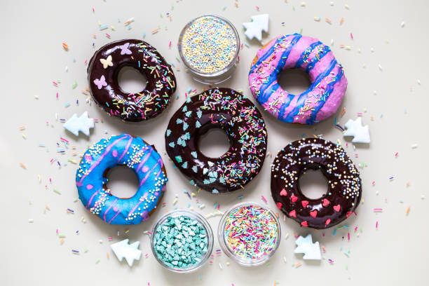 homemade doughnuts with colored frosting and sprinkles on white background