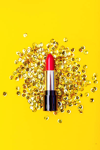 istock Red lipstick on a yellow background with sparkles. Vertical 1077687418