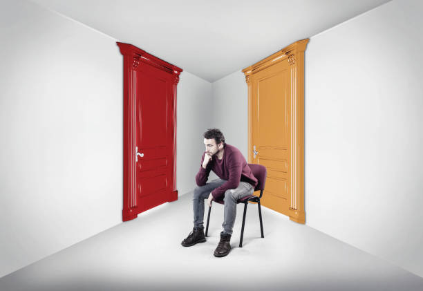 istock Thoughtful man between two doors. The concept of choosing the right path. 1077687614