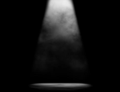 Simple black and white composition of dark stage with one light beam