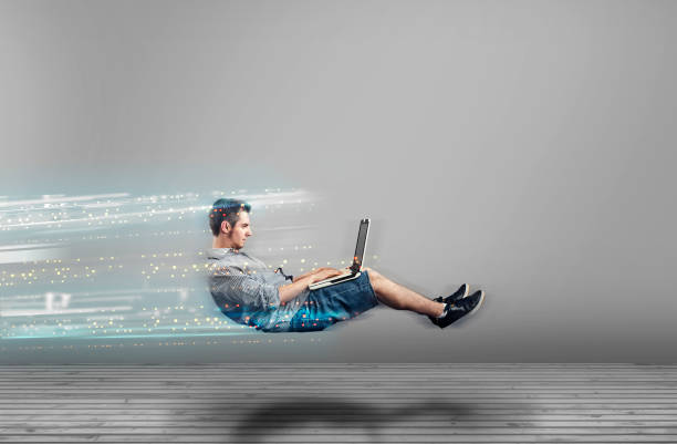 Fast levitating man in a white room using a laptop. High speed browsing. stock photo