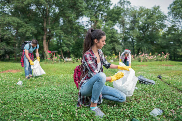 istock Young people gathering plastic litter in the park 1077689806