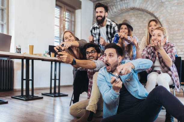 Coworkers playing video games in office