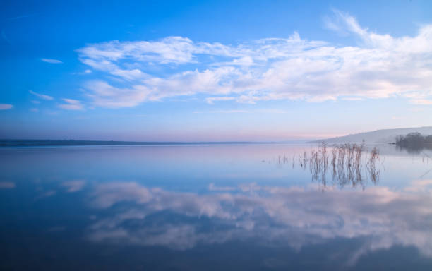 istock blue sky and clouds reflection in the lake stil water 1077691718