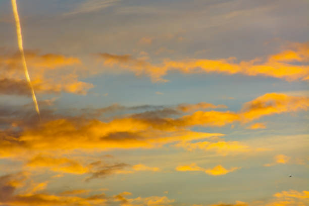 istock Bright morning orange sky. Footprints in the sky from the plane. 1077695586
