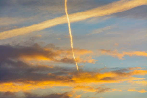 istock Bright morning orange sky. Footprints in the sky from the plane. 1077695646