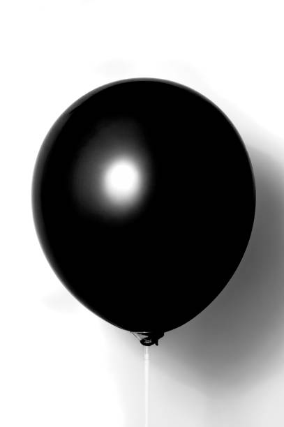 istock Black balloon on white background with shadow. Side glare. 1077699142