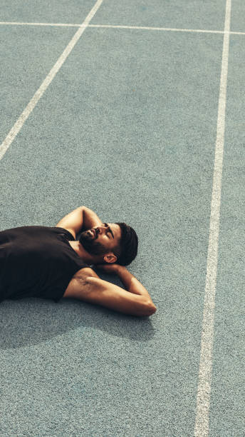 istock Athlete relaxing after the race on running track 1077699890