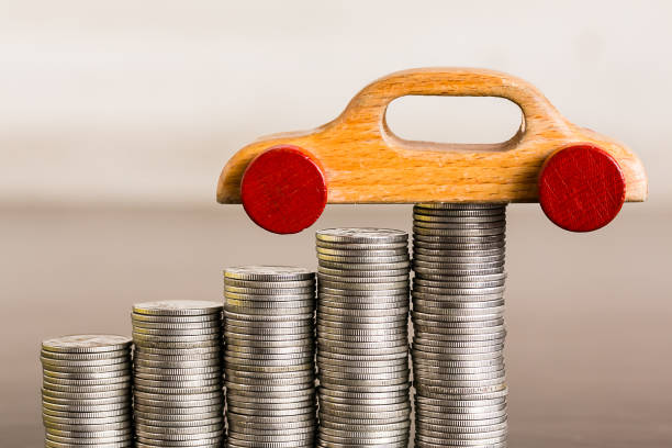 istock Stack of coins with wooden toy on wood table 1077700120