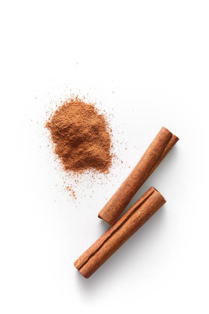 Cinnamon sticks and grounded cinnamon isolated on a white background. Cinnamon spice powder viewed from above. Top view. stock photo