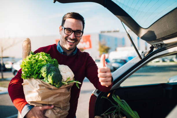 istock Man pointing thumb up after shopping 1077711684