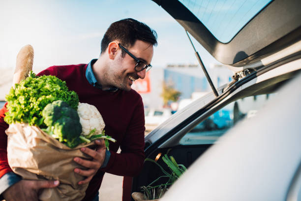 istock Man packing groceries into a car 1077711882