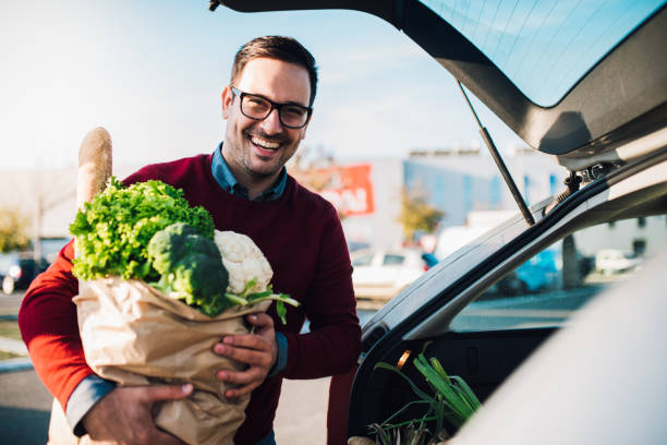 istock Smiling young man holding grocery bag 1077711902