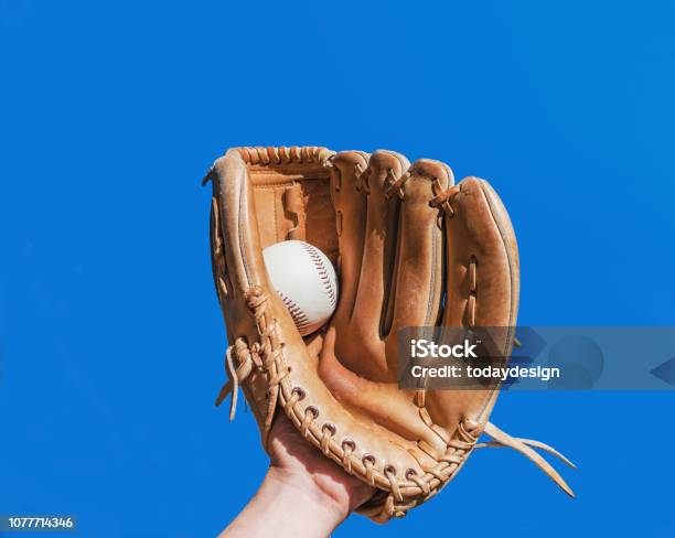 Hand In Glove For A Baseball Game Caught A Leather White Ball On A Blue Sky Background Sports Contests Victory Achievement Of Success Stock Photo - Download Image Now