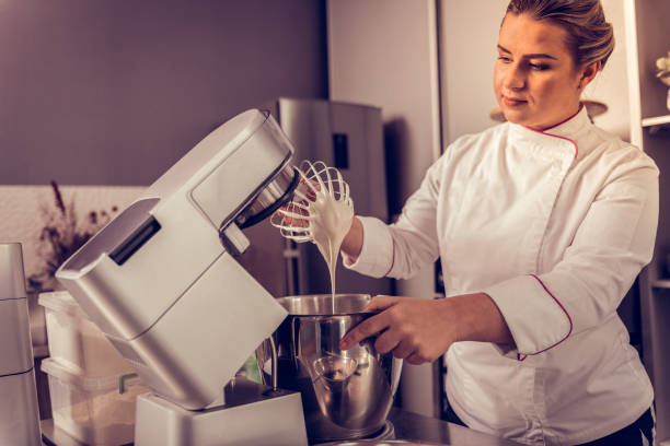 istock Nice serious woman standing near the kitchen machine 1077719024