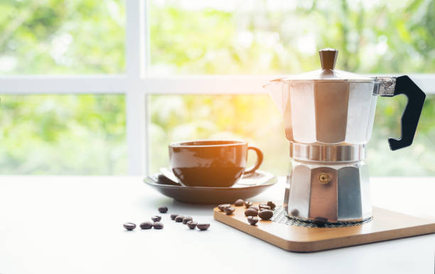 istock Close-Up Of Coffee Cup With Beans On Table Against Window 1077722210