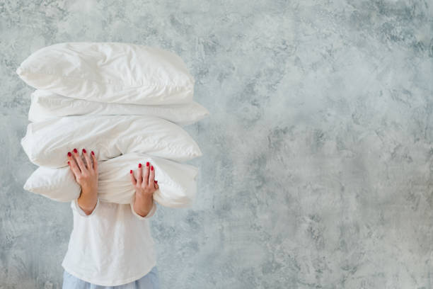 woman hold pile white pillows bedding sleeping - pillow imagens e fotografias de stock
