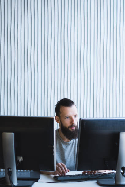 istock man work office two monitors bearded it specialist 1077723804