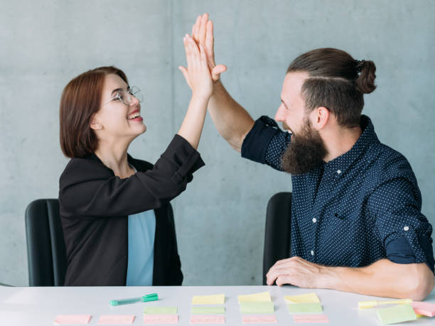 istock man woman high five office teamwork success 1077723870