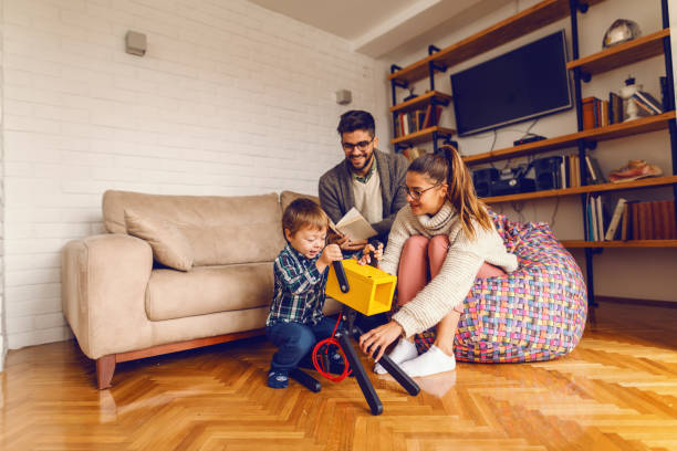 istock Cute little boy playing with dog-lamp while parents playing with him. Home interior. 1077727008