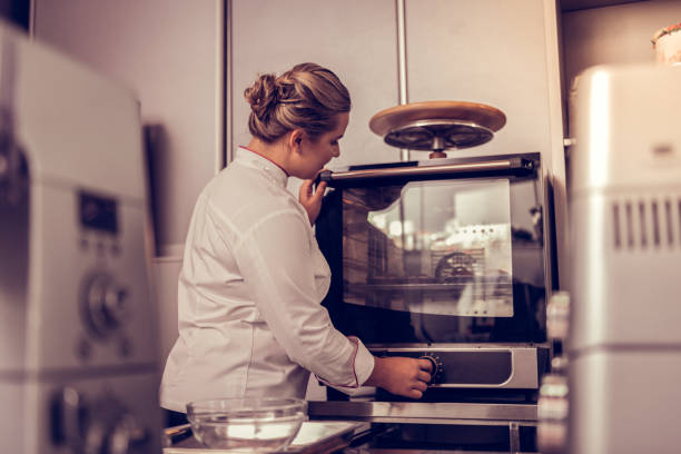 istock Professional skilled cook turning on the oven 1077730278