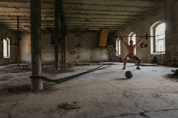 istock Athletic man doing overhead snatch in an old building 1077733006