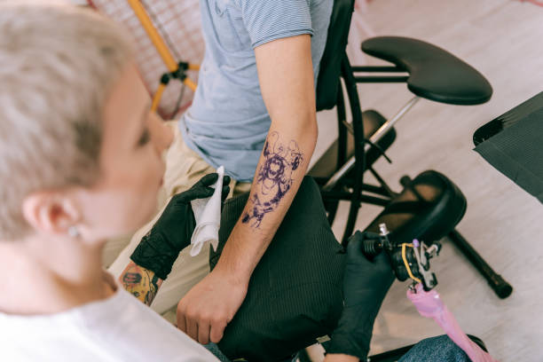 istock Professional tattoo master carrying special machine and cloth 1077740720