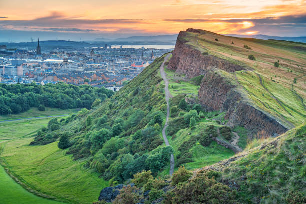 Salisbury Crags in Holyrood Park and downtown Edinburgh Scotland Stock photograph of Salisbury Crags in Holyrood Park and downtown Edinburgh Scotland UK during sunset edinburgh scotland photos stock pictures, royalty-free photos & images